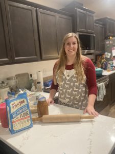 Woman standing behind kitchen counter with baking supplies